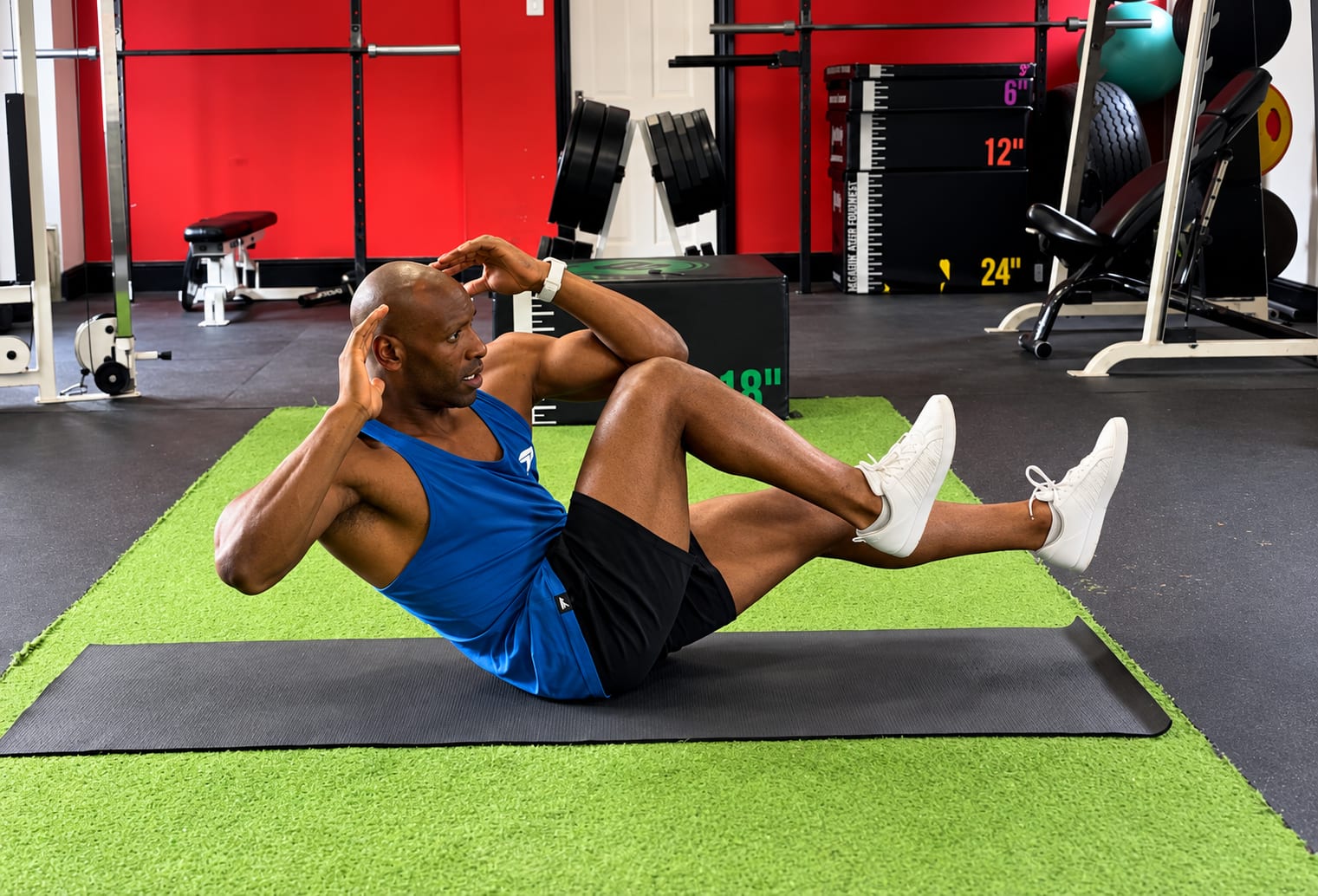 Mikey performing a core exercise on a mat in the gym